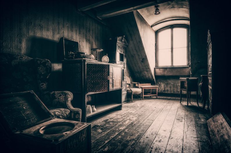 Attic - grayscale photo of wooden chair near window