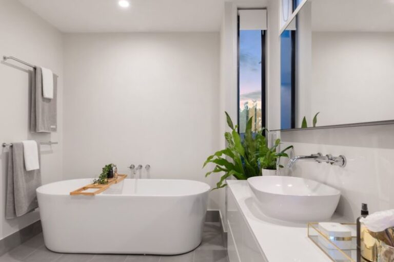 Bathroom - white ceramic bathtub near green potted plant
