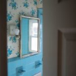 Bathroom Mirrors - a blue tiled bathroom with a mirror and sink