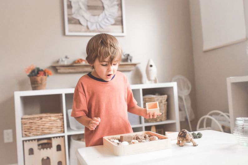 Children's Room - boy in orange crew neck t-shirt standing in front of white wooden table with cupcakes
